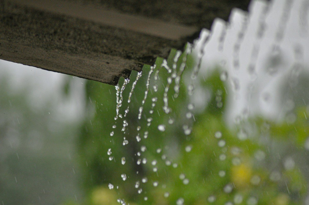 Rain streaming off the edge of a roof